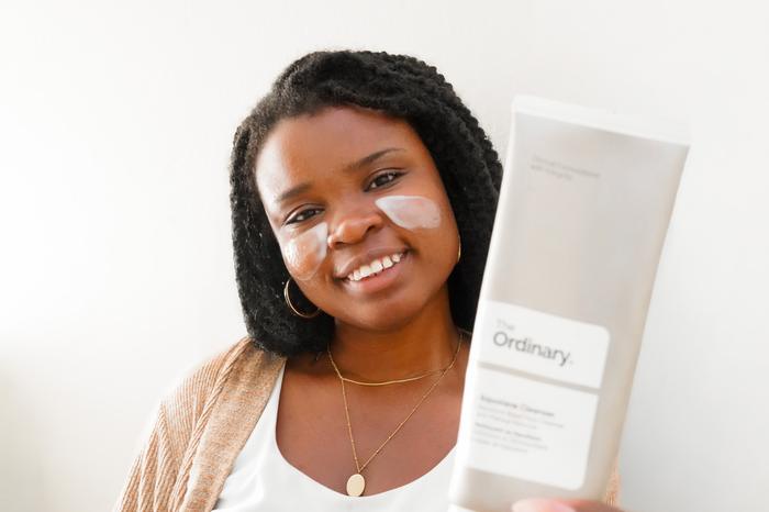 Faye Constant holding a skincare product