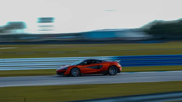 An orange sports car against the blurred trackside background