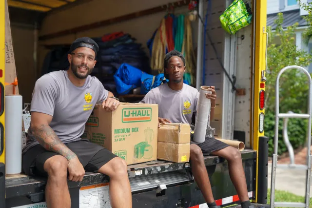 The Busy Bee Movers team smiling together on the truck ramp