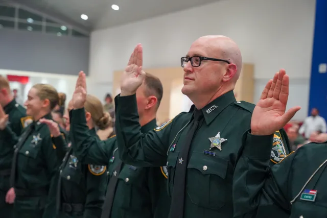 A graduate raising his right hand during the January graduation oath