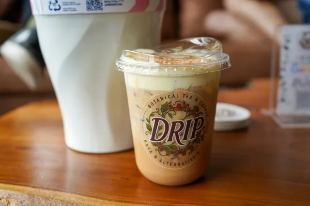 An iced coffee on a wooden café table