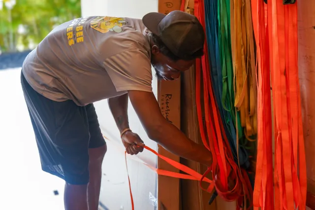 A mover fastening orange securing straps inside the truck