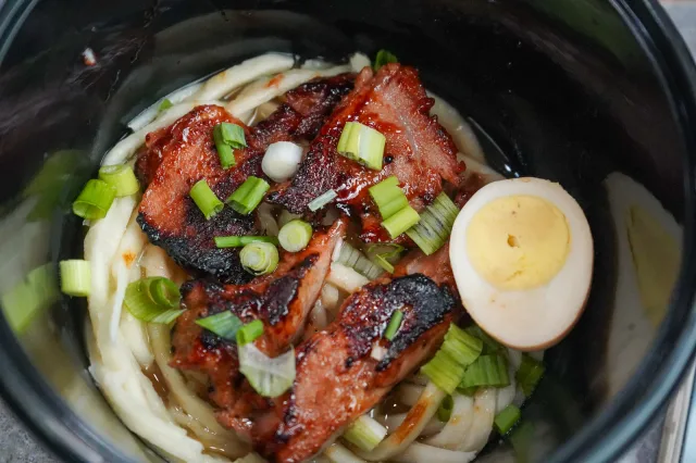 Glazed meat, greens and egg over noodles