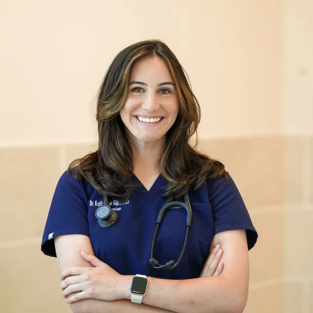 A VMC team member in navy scrubs with her arms folded