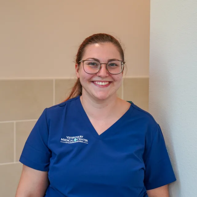 A VMC team member in blue scrubs smiling directly at the camera