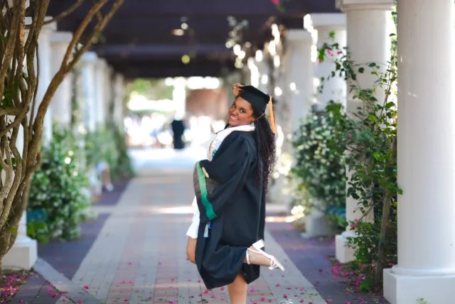 Ermeline Constant in her graduation gown beneath the USF walkway