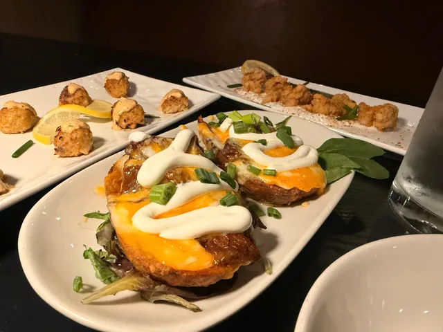 Close view of brisket potato skins on a table of dishes at GROVE