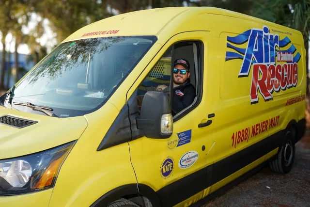 An Air Rescue technician in a yellow branded service van