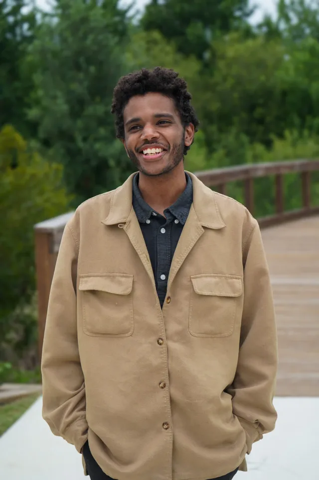 A smiling standing portrait beside the bridge
