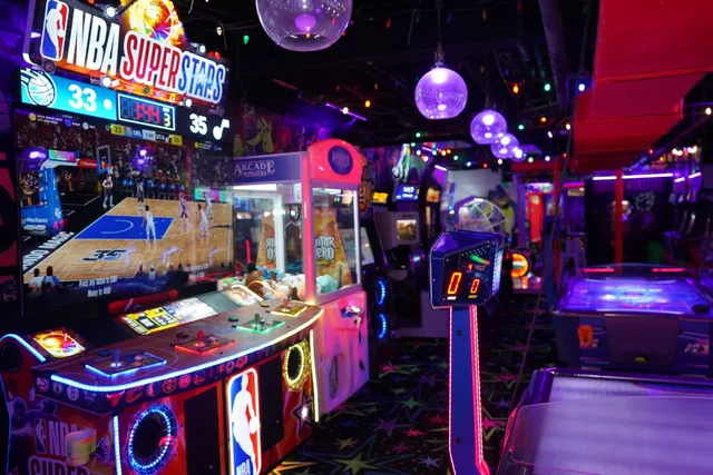 Neon-lit arcade games and air hockey tables at Arcade Monsters