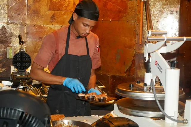 A cook preparing food in the open kitchen